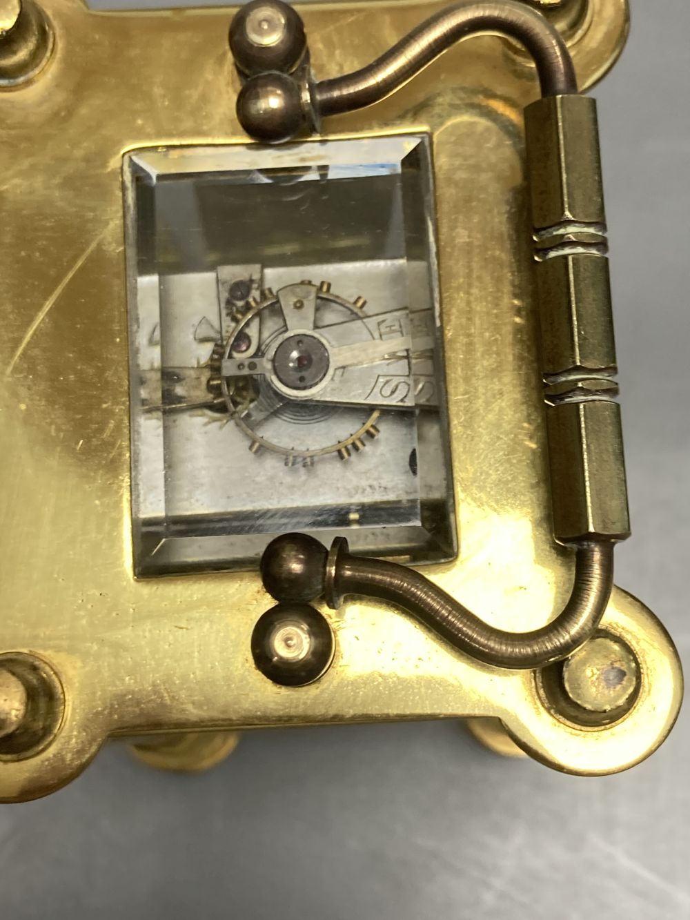 A brass timepiece with four glass panels and filigree decoration
